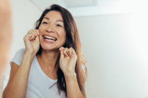 Woman flossing around her dental implant