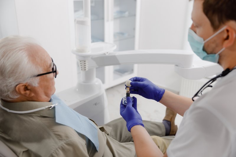 older man listening to dentist discuss dental implants