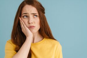Woman clutching jaw in pain from toothache. 