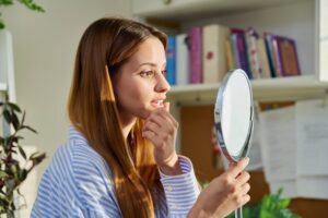 Woman looking at her teeth in the mirror